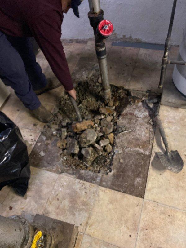 Excavated floor to access damaged underground pipe showing signs of corrosion and deterioration. Work area was properly prepared with necessary tools for the repair operation. Client made partial payment via check, with excavation scheduled for completion tomorrow at noon as confirmed with Julio.