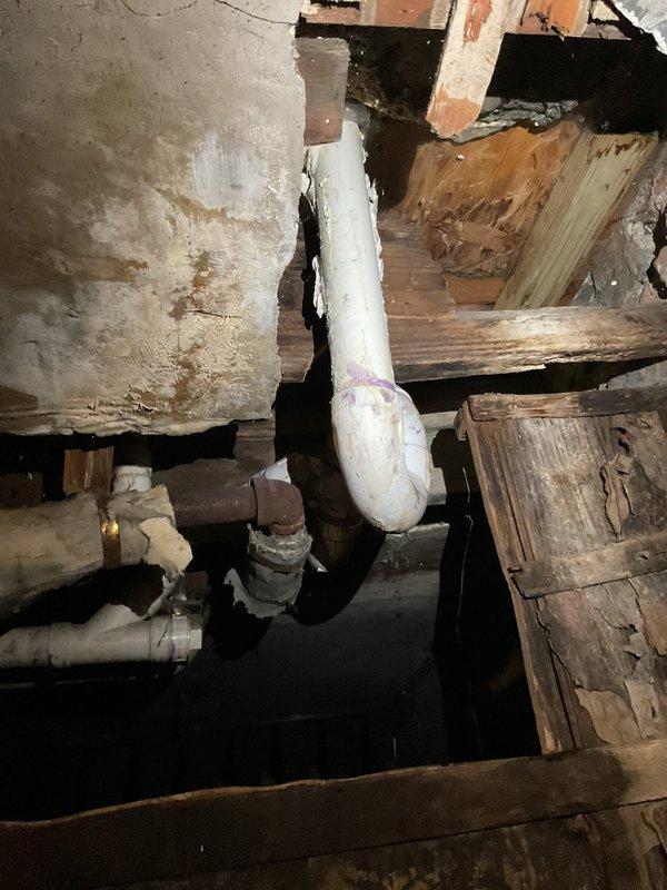 Performed inspection of basement plumbing system and identified damaged PVC drainage pipe with visible insulation protrusion. Replaced deteriorated section of sink drain line and addressed water leak affecting building sink. Repaired connection between older metallic plumbing components and PVC pipes, ensuring proper sealing at junction points to prevent future leakage.