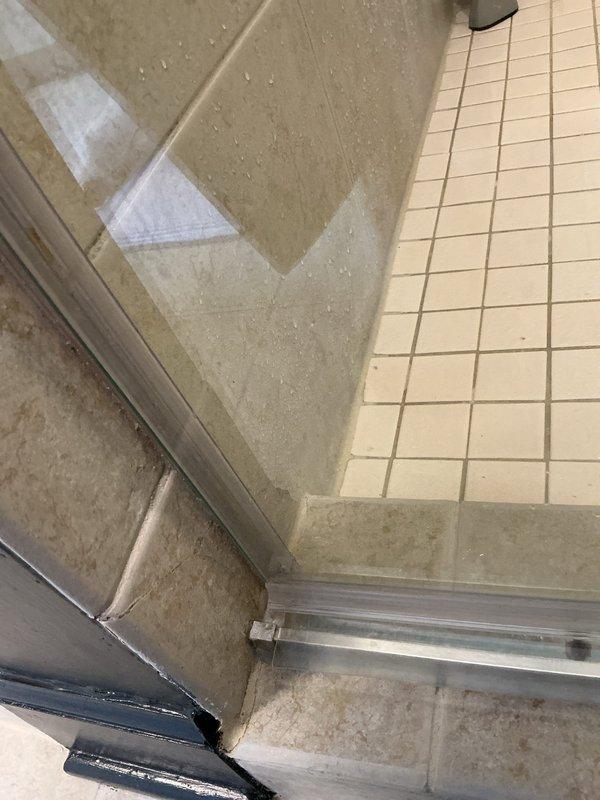 Responded to water leak service call for a VIP client who reported a brown spot on laundry room ceiling. Upon inspection, identified source of leak coming from the shower enclosure in the bathroom above, with water penetrating through the floor/ceiling junction due to deteriorated shower door seal and track. Documented ceiling water damage and shower condition with photos for client records.