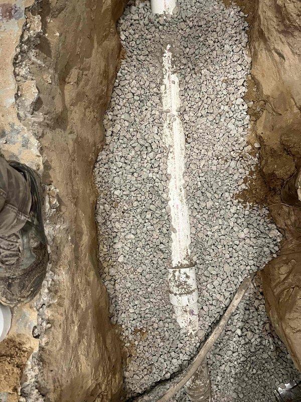 Excavated damaged area and installed new PVC drainage pipe with proper gravel bedding. Existing structure showed significant deterioration with extensive cracking, requiring complete removal and replacement of the affected section.