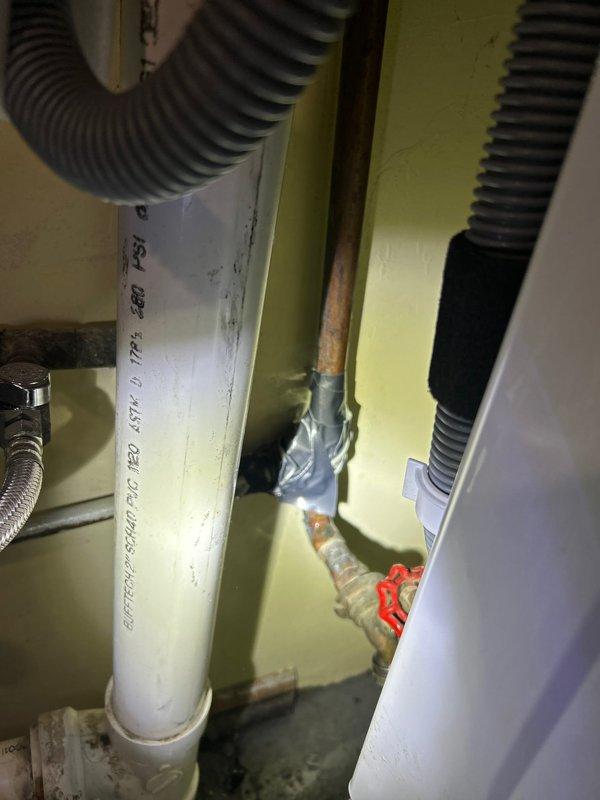 Responded to water leak call and identified source at copper pipe joint in utility room. Repaired compromised section of pipe using metal tape to seal the leak. Inspected surrounding plumbing system including water heater connections, PVC drainage, and flexible supply lines to ensure no additional leaks were present. All valves and fittings were tested for proper operation after repair.