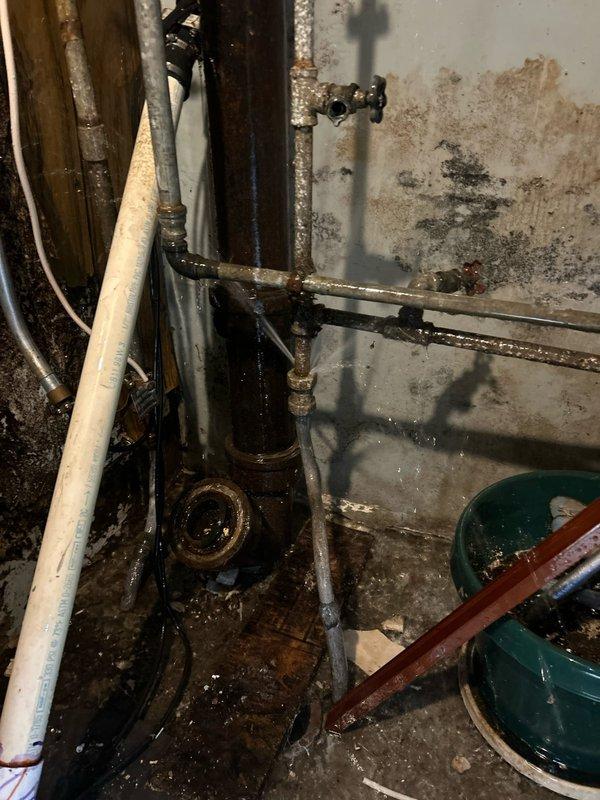Responded to emergency call after previous pipe thawing attempt resulted in pipe burst. Observed significant water damage and mold on walls with corrosion on metal pipes. Repaired burst section, replaced damaged galvanized piping with new materials, and verified system integrity with pressure test.