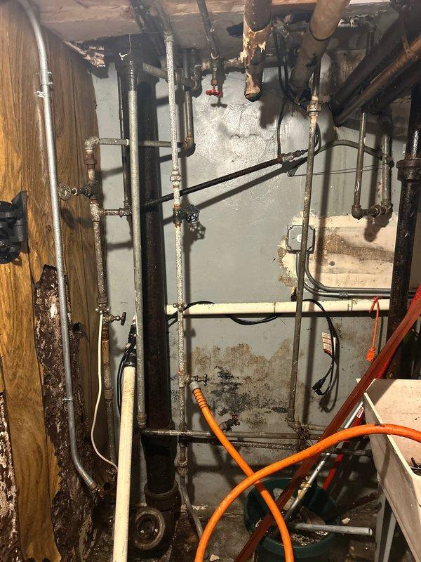 Responded to emergency call after previous pipe thawing attempt resulted in pipe burst. Observed significant water damage and mold on walls with corrosion on metal pipes. Repaired burst section, replaced damaged galvanized piping with new materials, and verified system integrity with pressure test.