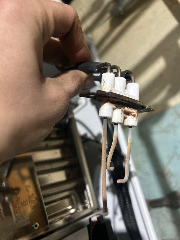 Inspected customer's plumbing system regarding persistent low water pressure complaint. Discovered significant corrosion and oxidation on metal components of the water supply assembly. Removed and examined damaged pressure regulator components showing ceramic insulators with corroded terminals and connection points. Further investigation required to fully resolve the ongoing pressure issues.