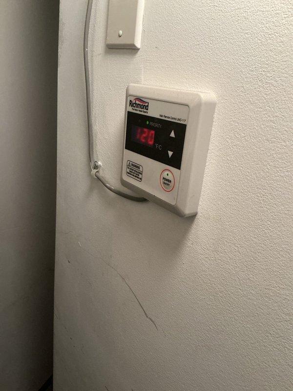 Conducted on-site estimate for replacement of existing Richmond tankless water heater with new unit. Current system includes wall-mounted digital temperature controller (121°F setting) and vertical PVC venting. Customer interested in financing options for the replacement project.