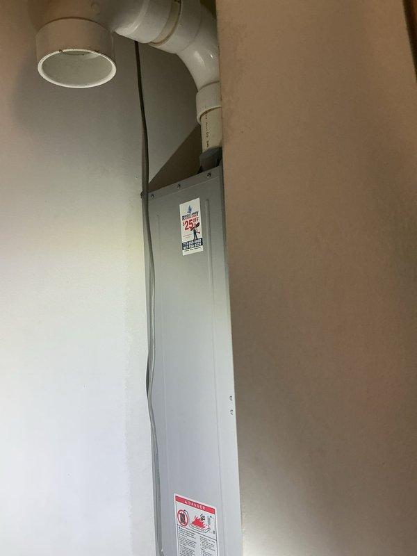 Conducted on-site estimate for replacement of existing Richmond tankless water heater with new unit. Current system includes wall-mounted digital temperature controller (121°F setting) and vertical PVC venting. Customer interested in financing options for the replacement project.