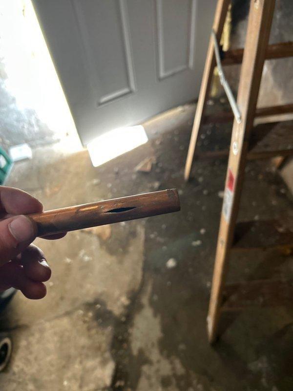 Investigated water leakage from first floor into basement unit as referenced in invoice #169402950. Located compromised copper pipe with visible hole/puncture causing the leak. Inspected and documented existing plumbing system with exposed copper supply lines requiring attention. Confirmed issue was connected to previously identified problem in neighboring unit.