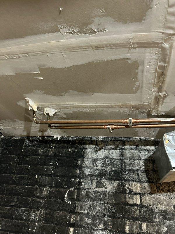 Investigated water leakage from first floor into basement unit as referenced in invoice #169402950. Located compromised copper pipe with visible hole/puncture causing the leak. Inspected and documented existing plumbing system with exposed copper supply lines requiring attention. Confirmed issue was connected to previously identified problem in neighboring unit.
