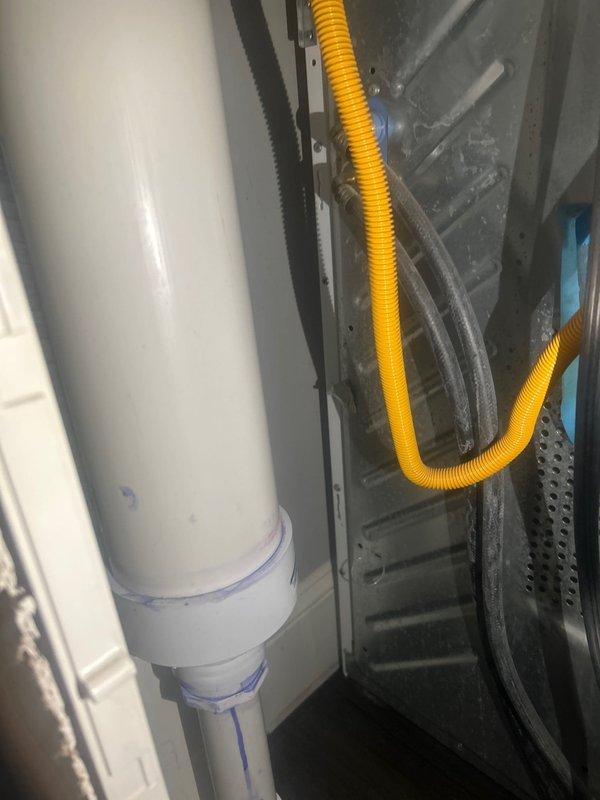 Responded to a water leak report behind customer's washing machine involving a PVC pipe. Inspection of the area revealed water seepage from a connection point in the plumbing system. Identified and documented the source of the leak in the mechanical enclosure where the PVC pipe connects to flexible tubing.