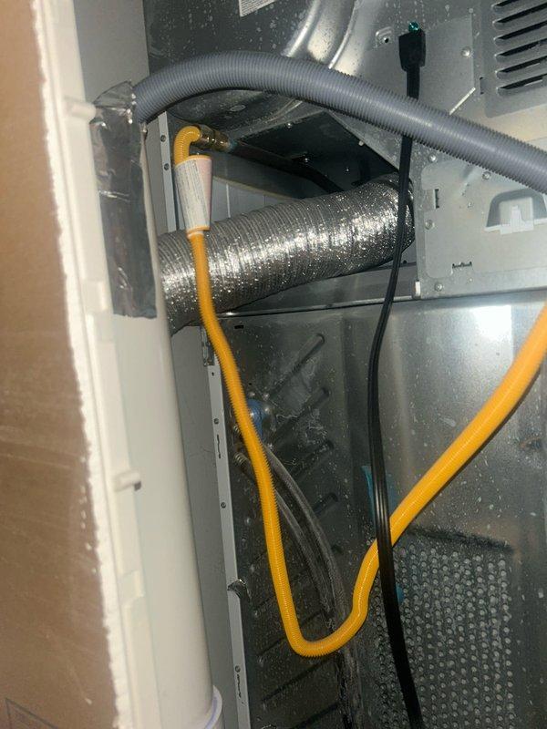 Responded to a water leak report behind customer's washing machine involving a PVC pipe. Inspection of the area revealed water seepage from a connection point in the plumbing system. Identified and documented the source of the leak in the mechanical enclosure where the PVC pipe connects to flexible tubing.