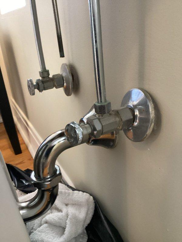 Located and repaired two leaks in bathroom sink plumbing: tightened loose connection on chrome P-trap J-bend and replaced faulty hot water angle stop valve. Tested all connections to confirm proper function with no further dripping observed.