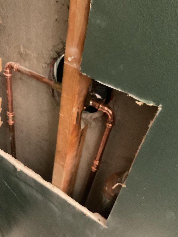 Returned to property to complete a previously sold repair job. Accessed the shower plumbing through a wall panel to service the shower fixture and associated copper supply lines. Completed necessary repairs to the shower system in the green-tiled bathroom enclosure.