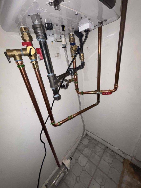 Successfully completed installation of a new tankless water heater system, replacing the previous tank-style unit. Work included configuring copper supply lines, installing necessary valves and fittings, and ensuring proper connection of pressure relief valve. All components were tested and verified to be functioning correctly.