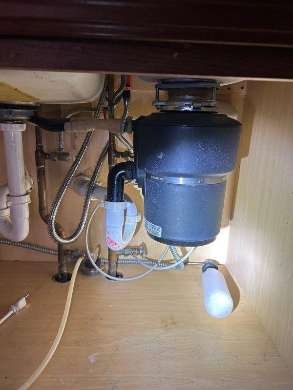 Inspected property for sump pump installation requirements. Evaluated existing kitchen sink plumbing system, noting functional garbage disposal unit with proper drainage connections. Customer not present during assessment; accessed property using provided door code (2377). Will return to complete installation when black shower valve arrives, with follow-up call to confirm customer availability.