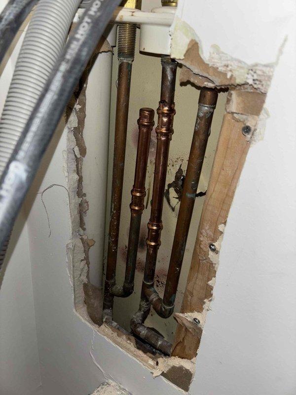 Responded to priority water leak service call. Upon inspection, discovered corroded copper pipes behind wall requiring access cutout. Replaced damaged section of piping with new copper fittings near the Rheem Performance Platinum water heater installation, restoring proper function and preventing further water damage.
