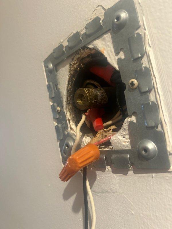 Performed inspection of reported gas leak at light fixture location. Accessed wall junction box which revealed improper gas line installation in proximity to electrical components. Observed brass gas fitting with threading and valve handles adjacent to electrical wiring with wire nuts. Gas supply to this line was confirmed shut off for safety. Documented installation with photos showing the hazardous configuration for reference.
