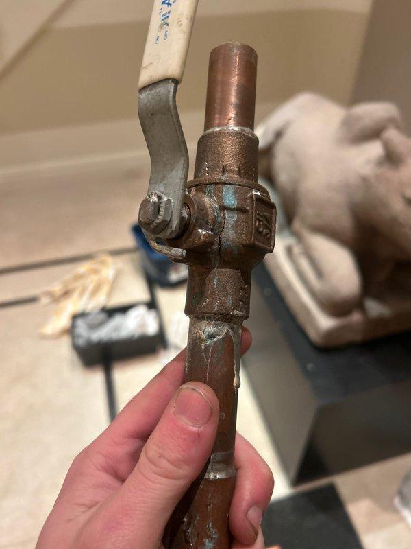 Responded to emergency service call for frozen pipes causing water leak. Inspected copper pipe system showing significant corrosion and oxidation. Located and replaced damaged valve assembly, addressing pipe sections exhibiting green patina formation. Restored proper water flow and verified system integrity after repair.