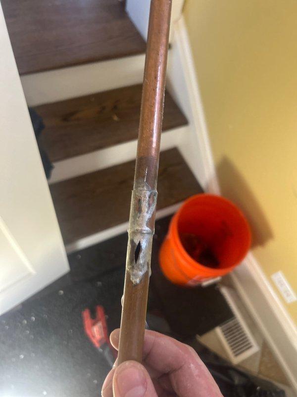 Responded to emergency call for burst copper pipe in basement. Located and removed damaged section of pipe with significant corrosion and failed temporary seal/adhesive repair. Installed electronic flow monitoring device to the replacement pipe segment to prevent future incidents, with proper connection to existing system. Tested system for proper operation and pressure integrity before completion.