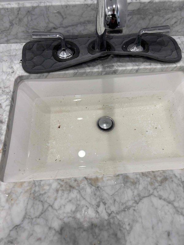 Responded to service call for slow-draining bathroom sink. Performed drain cleaning procedure to remove blockage and restore proper drainage. Also inspected reported toilet leak but found toilet to be functioning normally with no evidence of leakage around base or tank.