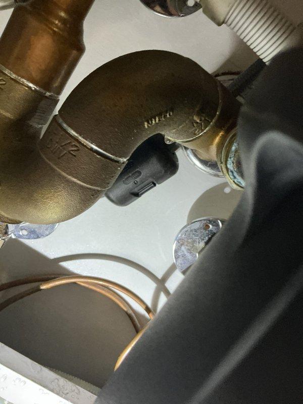 Responded to a kitchen sink overflow issue. Inspected under-sink components including garbage disposal unit, copper plumbing, and filtration system. Serviced brass shutoff valve and elbow fitting that were causing the clog, restoring proper drainage function.