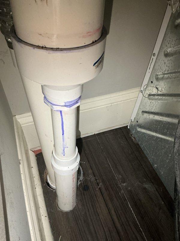 Responded to a callback service request for a laundry drain obstruction that could not be cleared during previous visit. Inspected the stacked washer/dryer installation and associated PVC drain system. Located blockage in the main vertical waste line where blue marker lines were visible. Successfully cleared the obstruction and verified proper drainage. Water marks on floor near drain connection were cleaned and system was tested to ensure full functionality.
