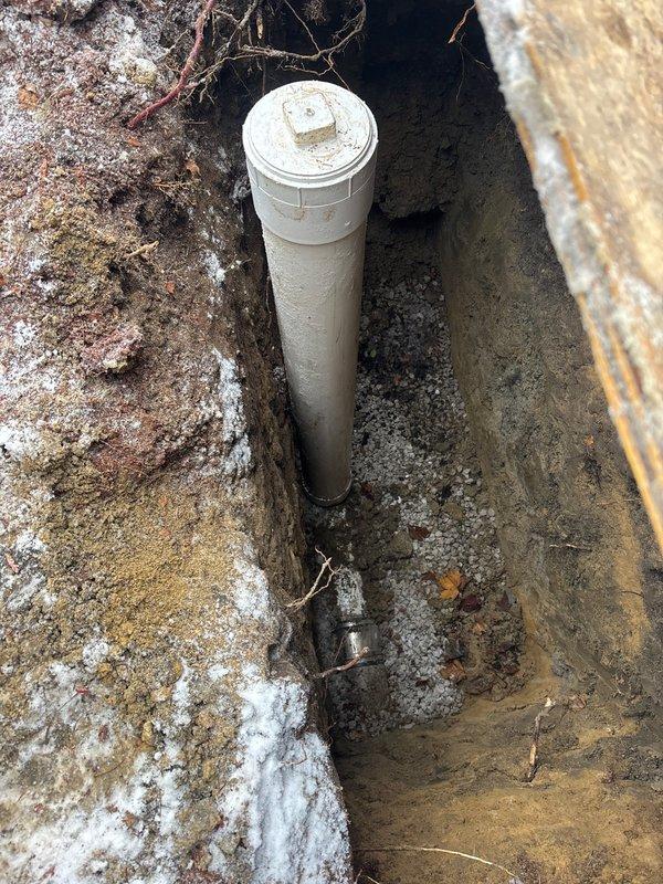 Completed excavation and installation of water service line with new meter housing. Installed vertical PVC standpipe with access cap to protect connection point. Properly backfilled trench with appropriate bedding material around pipe connections.