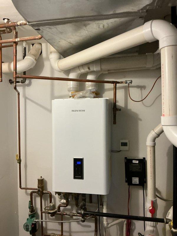 Diagnosed and corrected cross-connection issue causing hot water to flow into cold water lines. Inspected Navien tankless water heater system and associated plumbing components. Adjusted check valves and balanced pressure between hot and cold water lines to eliminate backflow problems.