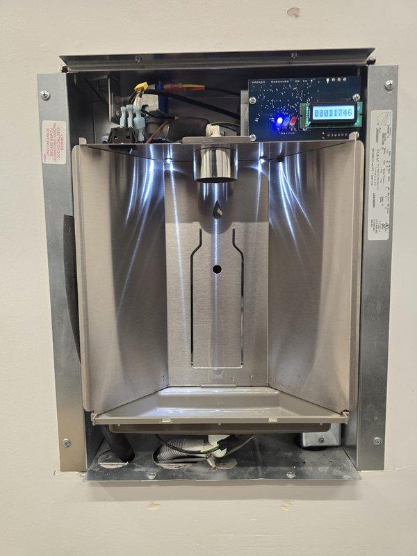 Performed inspection of wall-mounted water heater unit as sold by Lowden. Accessed internal components, documented condition of stainless steel chamber and electrical connections. Verified proper operation of control panel with digital display (reading 00012709) and confirmed LED indicator functionality.