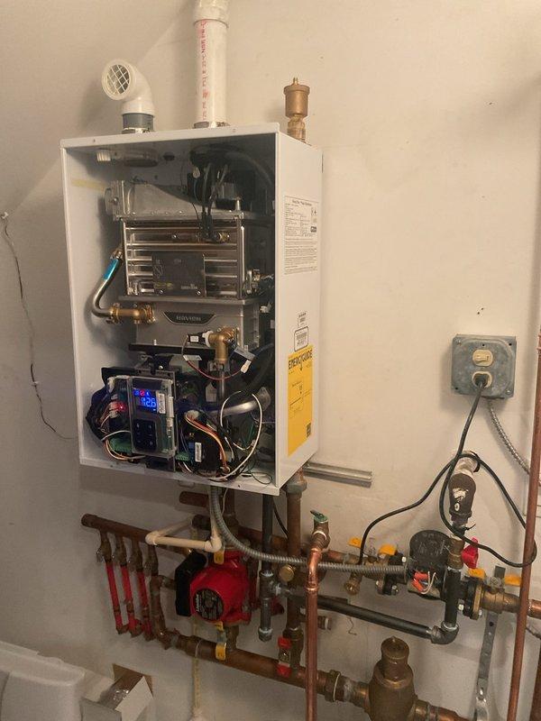 Responded to service call from Nick B. Inspected tankless water heater system with circulation pump and associated plumbing components. Verified proper installation of PVC venting and electrical connections. Also examined bathroom toilet for reported issues; no visible damage observed.