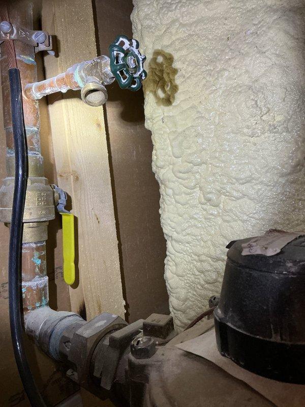 Performed diagnostic inspection to locate water leak reported through first floor ceiling. Inspected second floor washing machine connections and surrounding plumbing. Examined copper supply lines with green and yellow valve handles in utility area. Discovered leak source at Honeywell control unit connection where copper line meets wall. Sealed connection point and verified proper operation of system. Recommended monitoring repaired area for 24-48 hours to ensure complete resolution.