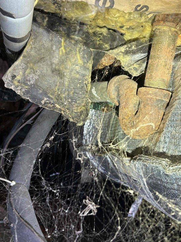 Responded to customer request for water leak investigation in a confined crawl space. Upon inspection, identified a heavily corroded copper pipe fitting with active leak. Observed significant corrosion damage, moisture accumulation on concrete surface, and deteriorated insulation in the surrounding area.