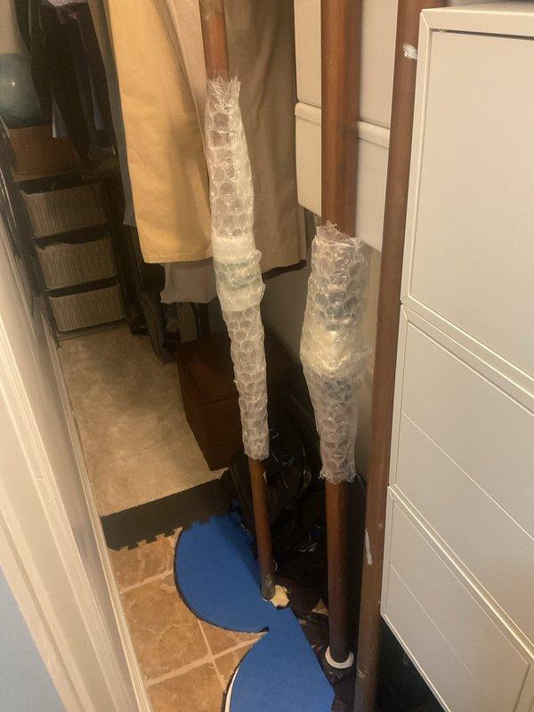 Responded to dispatch call for tanked water heater service. Inspected existing water heater system which was winterized as indicated by attached notice. Observed proper ventilation and connection components including copper piping. Noted protective bubble wrap on vertical copper pipes in utility area, suggesting recent installation or ongoing work.
