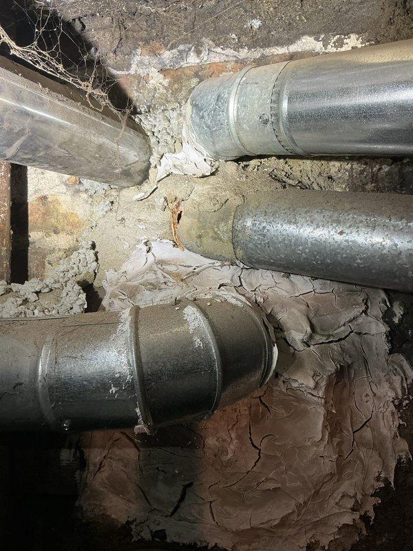 Performed inspection of 40-gallon water heater installed in 2013 that has ceased to produce hot water as of yesterday. Observed significant deterioration around pipe penetrations with cracking and crumbling material. Noted galvanized metal pipes showing age-related wear. Evaluated PVC piping system in utility area with particular attention to connection points. Provided customer with replacement options for the failing unit.