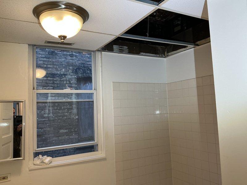 Conducted on-site assessment for customer's request to install a new bathroom in existing building. Inspection revealed significant ceiling damage with exposed wooden joists and deteriorated substrate material, likely indicating previous water damage or aging infrastructure. Bathroom currently has partial tile walls and requires complete renovation before new plumbing installation can proceed.