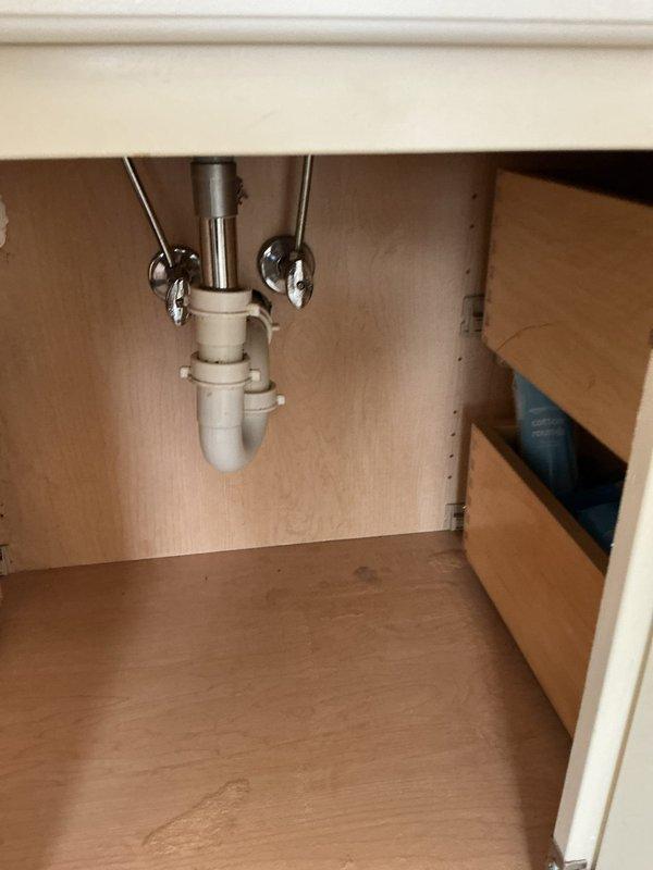 Responded to service call for clogged drain/sink. Inspected kitchen sink P-trap assembly and drainage system. Observed water staining on cabinet floor indicating previous minor leakage. Also examined basement plumbing infrastructure, noting deteriorated pipe insulation that requires attention. Cleared blockage and verified proper drainage function.