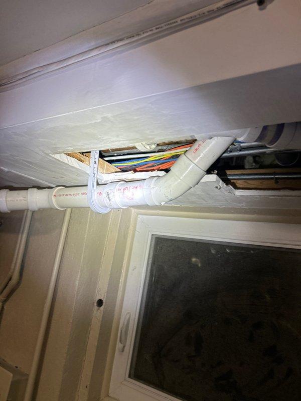 Responded to service call regarding clogged garbage disposal. Upon inspection, discovered plumbing issues extending to ceiling/wall areas where PVC piping and electrical work were exposed. Accessed utility room to examine connected plumbing systems, noting water damage in ceiling area with exposed pipes that required attention to properly resolve the disposal clog.