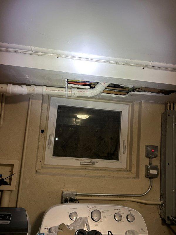 Responded to service call regarding clogged garbage disposal. Upon inspection, discovered plumbing issues extending to ceiling/wall areas where PVC piping and electrical work were exposed. Accessed utility room to examine connected plumbing systems, noting water damage in ceiling area with exposed pipes that required attention to properly resolve the disposal clog.