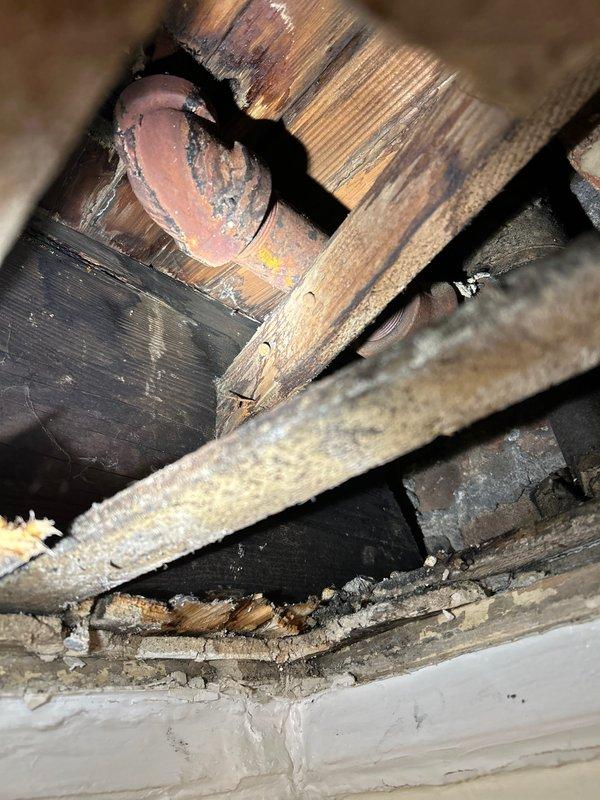 Conducted leak investigation in bathroom area following reported water damage to unit below. Inspection revealed significant corrosion on copper supply pipe beneath flooring near radiator installation. Located and repaired the compromised pipe section, which showed advanced oxidation and material failure consistent with long-term moisture exposure. System was pressure tested after repair to confirm leak resolution.