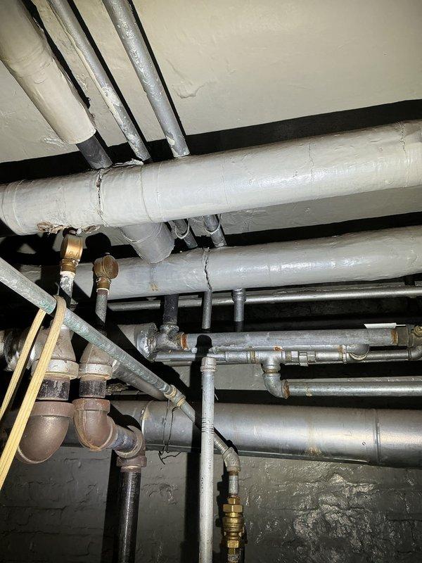 Inspected 5-unit building with reported low water pressure and extended hot water wait times. Examination of the main plumbing infrastructure revealed mineral buildup and scaling in pipes, particularly at connection points. Cleaned key valves and pressure regulators, adjusted water pressure settings to optimal levels, and flushed the system to remove sediment accumulation that was restricting flow.
