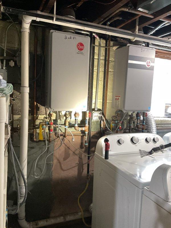 Responded to service call for tankless water heater system. Inspected dual Rheem tankless units mounted in basement (labeled "1st Fl." and "2nd Fl.") with associated copper and PVC piping. Performed maintenance check on exterior components including condenser unit and electrical connections. Service was sold by Jose.