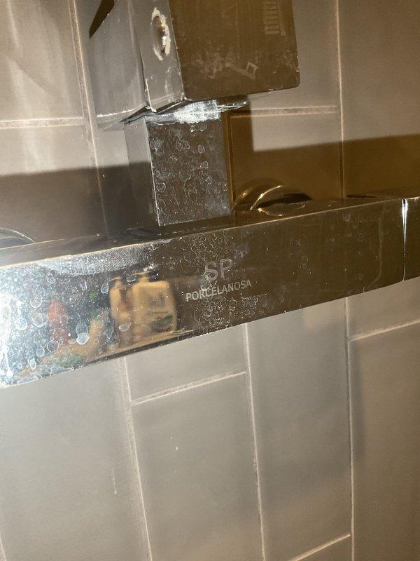Responded to a service call for a leaky showerhead in a residential bathroom. Upon inspection, found a PORCELANOSA shower fixture showing signs of water leakage. Repaired the faulty valve, tightened all connections, and verified proper operation with no further leakage.