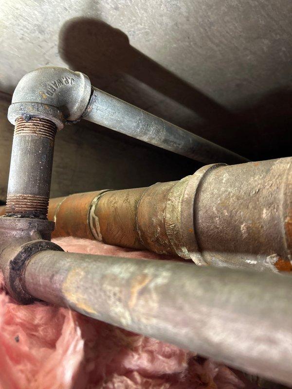 Identified and repaired water leak in aging supply line system. Inspection revealed significant corrosion at galvanized steel elbow joint connections with visible rust deterioration at threaded portions. Replaced affected section of pipe and insulated properly to prevent future moisture issues.