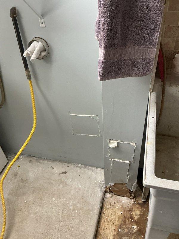 Conducted site visit for customer who requested evaluation of a suspected seal issue between washing machine and main stack. Inspection revealed deteriorated connection at the PVC to cast iron transition, showing significant corrosion and mineral deposits. Multiple wall sections had been previously opened with temporary patches visible. Documented condition of plumbing system and identified need for proper pipe transition repair to prevent further water damage.