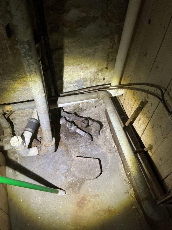 Responded to callback for Jon. Inspected basement utility space with visible water staining on concrete floor. Examined copper supply line showing significant corrosion and oxidation at joints with greenish-blue patina formation. Identified potential leakage at connection points and signs of water damage on surrounding wooden framing.