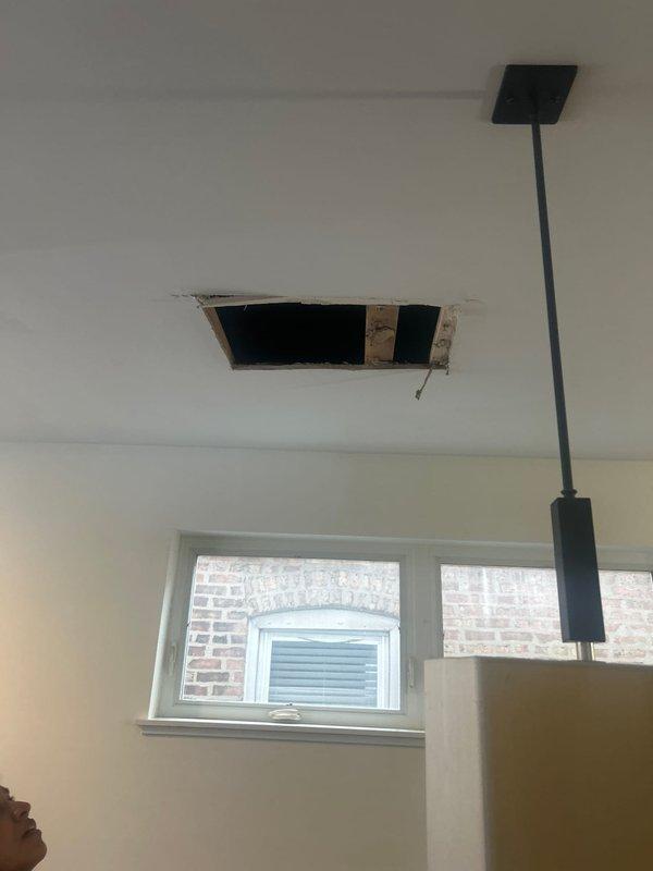 Responded to a water leak call affecting dining room ceiling. Upon inspection, identified the source as plumbing components in the upstairs bathroom. Located the specific leak point at a metal pipe connection with visible water tracking. Ceiling drywall had sustained significant damage with a section approximately 1-2 feet long already removed, exposing the framing. Completed diagnostic assessment and documented findings for repair planning.