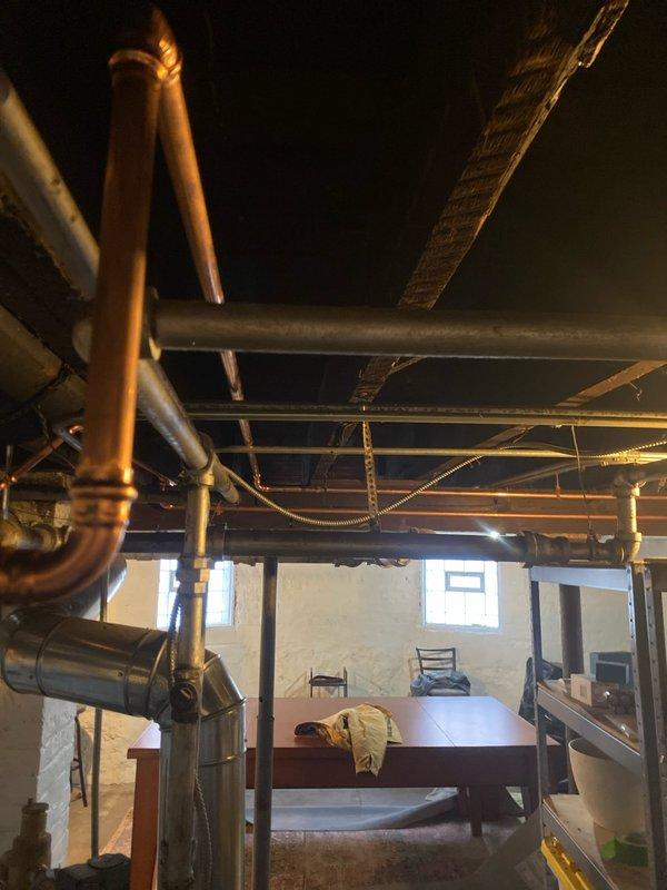 Installed new copper piping in basement utility area, including proper 90-degree elbow joints and secure bracket mounting. Connected system to existing PVC infrastructure and verified all connections for leaks. Parts provided by Joey.
