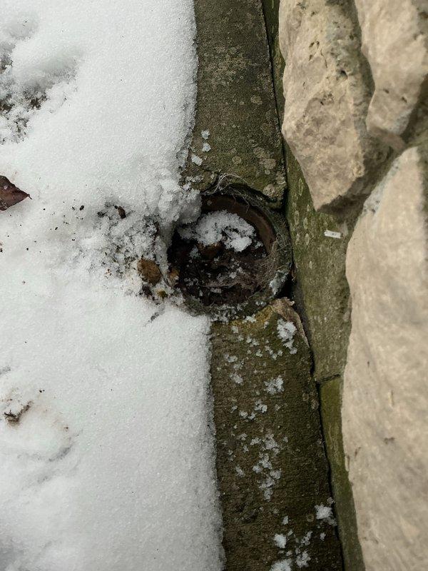 Investigated sewer odor complaint in laundry/powder room area. Client had attempted to flush drains without success in identifying source. Inspection revealed potential ventilation issues with air return grille and exterior drainage system. Observed outdoor drain with snow accumulation and possible moss/algae growth that may be contributing to the problem.