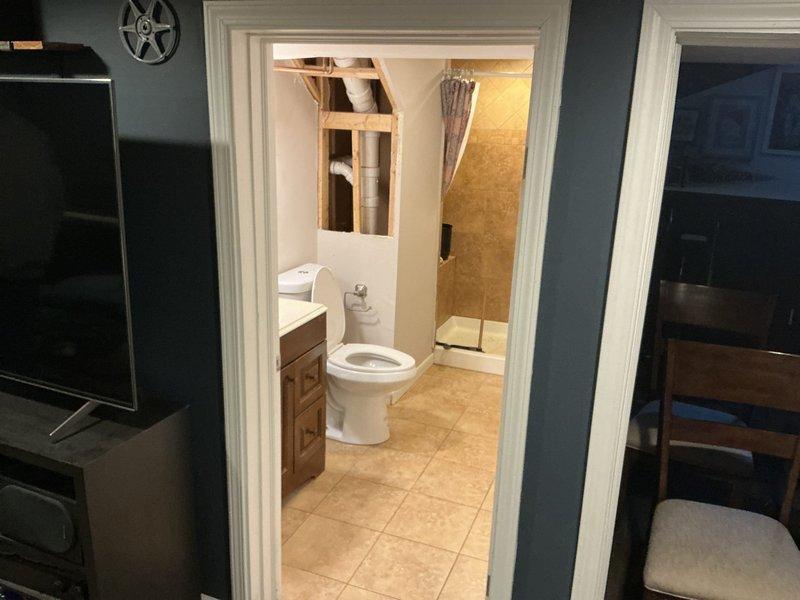 Responded to service call for multiple drain backups affecting toilets, floor drains, shower, and kitchen sink. Visual inspection revealed potential main line blockage affecting multiple fixtures throughout the residence. Bathroom area showed signs of previous backups with water damage visible around fixtures. Recommended main line cleaning to resolve widespread drainage issues.