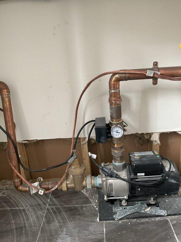 Conducted site visit to assess client's booster pump system. Inspected existing installation, which includes a black electric water pump mounted on the floor connected to copper piping network with pressure gauge. Photos taken of the setup for reference in preparing requested quote. Will coordinate with Anil to schedule follow-up appointment.