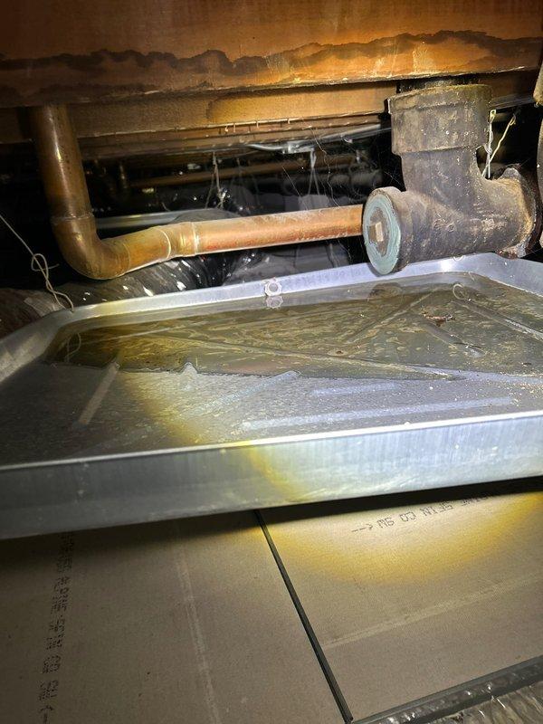 Responded to customer report of leaky pipe. Inspection revealed water seepage from valve connections in wall access panel containing hot and cold water supply lines. Repaired leaking valve fitting on copper pipe in crawlspace, cleaned accumulated moisture in drain pan, and verified proper system operation with no further leakage.